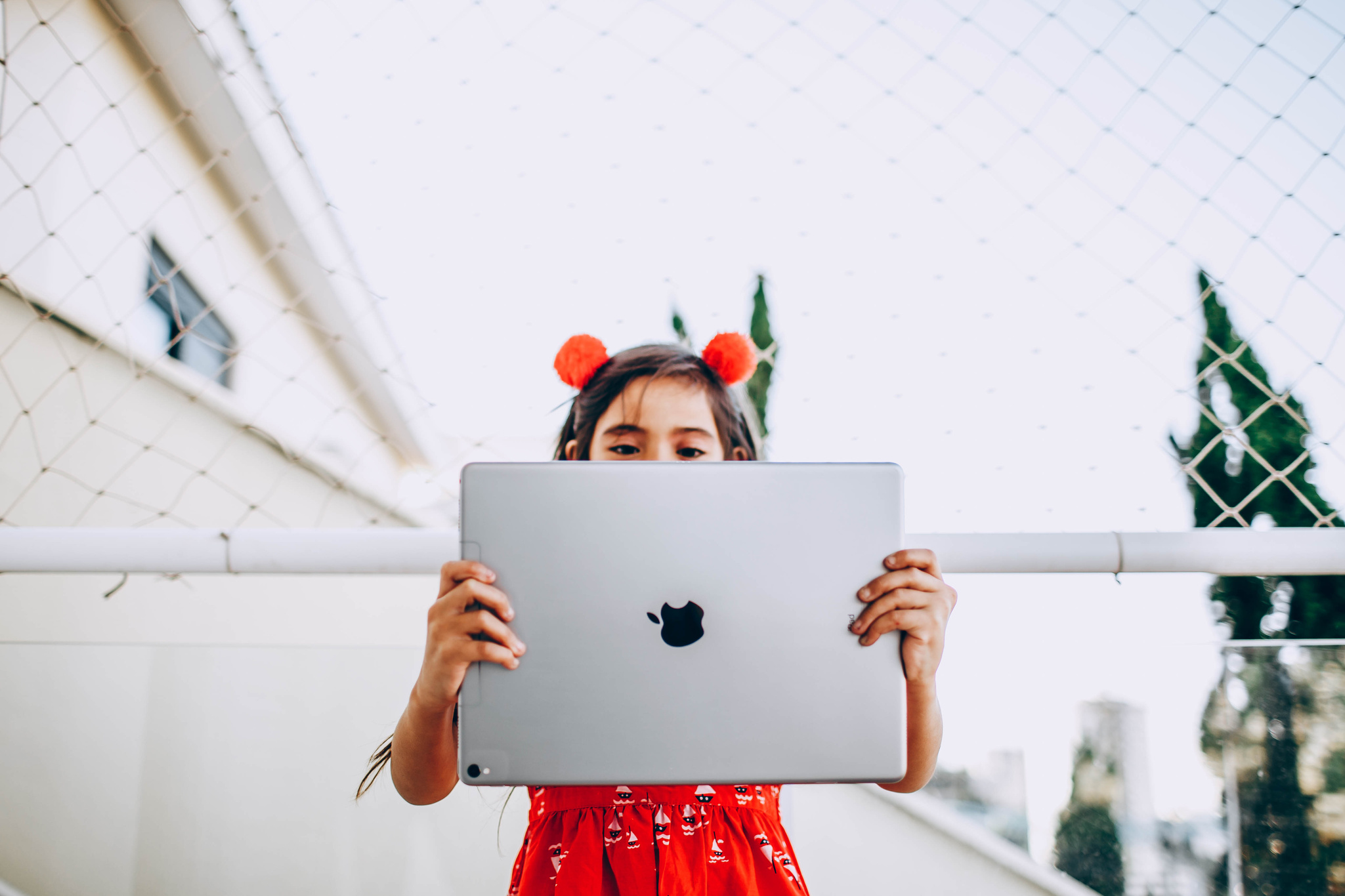 Photo of Girl in Red Dress Holding Silver Ipad Pro